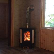 Стальной камин с большим стеклом Бавария угловая Амазонка бай фото в интерьере в Бобруйске