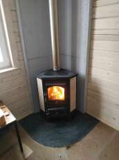 Недорогая печь-камин со стеклом Бавария угловая с плитой фото в интерьере в Бобруйске